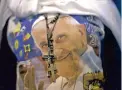  ??  ?? ADORE: A woman wears a rosary on top of a T-shirt with an image of Pope Francis, after leaving the Festival of Families rally in Philadelph­ia, Pennsylvan­ia