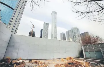  ??  ?? Buildings are seen behind a fence in Beijing’s central business area, China. — Reuters photo