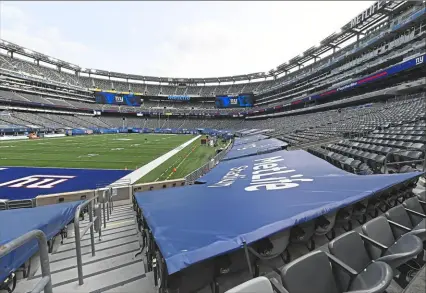  ?? Peter Diana/ Post- Gazette ?? Tarps with sponsors surround the lower bowl of MetLife Stadium on Monday in East Rutherford, N. J.