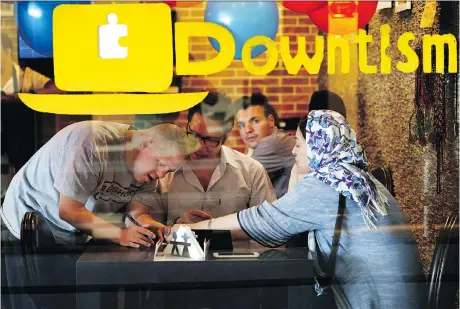  ?? PHOTOS: EBRAHIM NOROOZI/THE ASSOCIATED PRESS ?? Café staff member Ali Bakhti, with Down syndrome, left, takes an order in Downtism Cafe in Tehran. The popular café in the city’s Vanak Square opened only three months ago, but has been constantly bustling with customers.