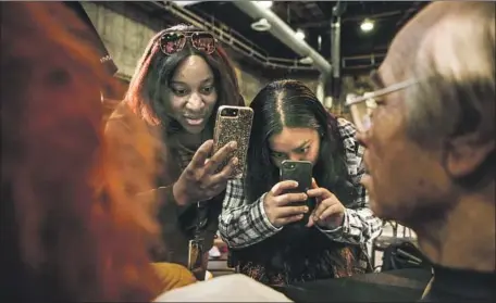  ?? Photograph­s by Maria Alejandra Cardona Los Angeles Times ?? ATTENDING an Academy Gold master class on the art of makeup, interns Tabia Johnson, left, and Claudia Juarez take photos of a mask.