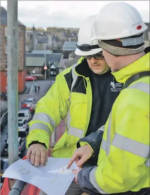  ??  ?? On the scaffoldin­g, high above Bolgam Street, McKinven and Colville site manager Fraser McNair discusses plans for the building’s dormer windows with conservati­on accredited architect Nick Blair. 25_c52CARS01