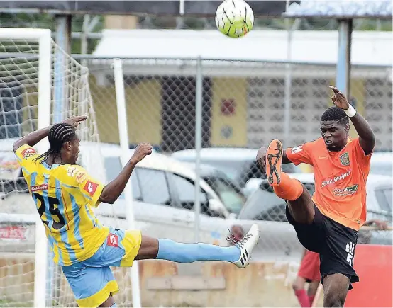  ?? IAN ALLEN ?? Barrington Price (right) of Tivoli Gardens clears the ball ahead of Keno Simpson of Waterhouse during a Red Stripe Premier League match at the Drewsland Stadium last season.