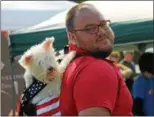  ?? KRISTI GARABRANDT — THE NEWS-HERALD ?? Cory Waldman of Beachwood piggy backs his dog around the Geauga Humane Society Rescue Village Woofstock event in a puppy sling.