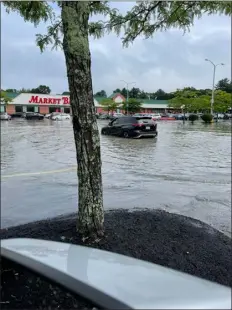  ?? COURTESY CHERYL CAPALDO WESINGER ?? The Aug. 8, 2023storm brought flash floods to parts of Billerica, including in the parking lot of the Market Basket at 700Boston Road, pictured here after 7.2inches of rain fell on the town in the span of just a few hours.