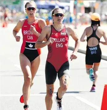  ?? CAMERON SPENCER/GETTY IMAGES ?? Vicky Holland of England, front, is chased down on Thursday by Joanna Brown of Canada in the race for bronze in the triathlon at the Gold Coast 2018 Commonweal­th Games in Australia.