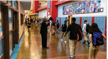  ?? JEREMY P. KELLEY / STAFF ?? New Belmont High School Principal Donetrus Hill uses a bullhorn to urge students to get to class on time. “Last year, these kids had a wasted year. There was nothing productive happening here.” he says.