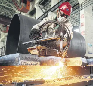  ?? ?? A worker produces manufactur­ing machinery at a factory in Nantong, in eastern Jiangsu province, China, May 26, 2021.