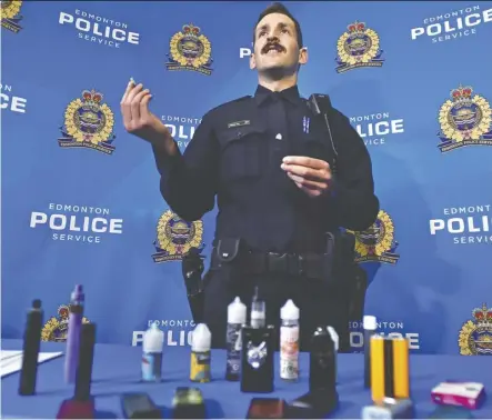  ?? Ed Kaiser ?? Const. Bryan Alm displays vaping products during a press event at Edmonton police headquarte­rs Tuesday. The items were seized from students. Alm says tobacco use among young people is on the rise.