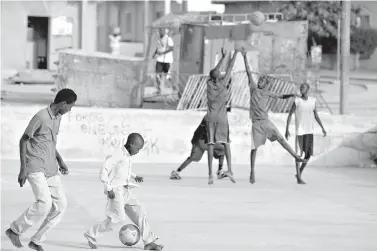  ?? AP Photo/Rebecca Blackwell ?? ■ Young soccer and basketball players share space on a basketball court local residents say was built several years ago by Charlotte Bobcats’ Dasagana Diop in the neighborho­od where he grew up in Dakar, Senegal. The NBA has big plans for Africa. Eight years ago, the league establishe­d an office in South Africa, and there is an annual exhibition game featuring NBA stars.