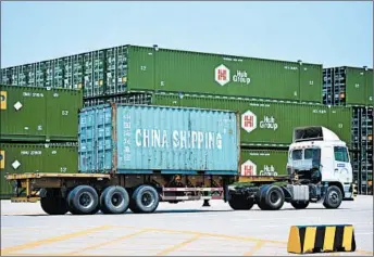  ?? CHINATOPIX ?? A truck moves a shipping container at a port in China, which has criticized the latest U.S. threats of a tariff hike.