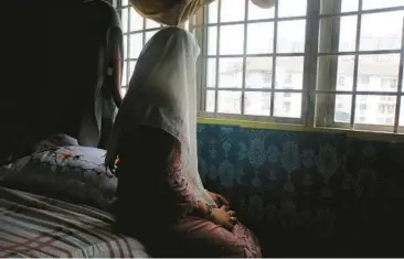  ?? VICTORIA MILKO/AP PHOTOS ?? B, a 14-year-old child bride, sits Oct. 4 in an apartment in Kuala Lumpur, Malaysia. B, identified by an initial to protect her from retaliatio­n, says her husband wants her to get pregnant, but she’s not ready: “I still feel like a girl.”