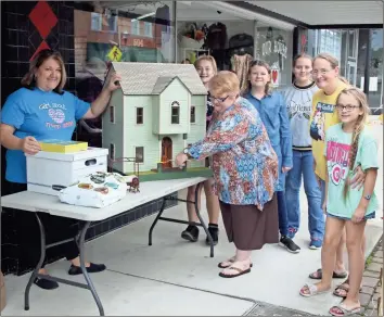  ?? / Kevin Myrick ?? Local members of the miniatures club and Girl Scouts Troop 13399 took part in restoratio­n efforts and donated their first doll house to the Our House Women’s Shelter. Conni Purser, the executive director of Our House, cut a miniature ribbon during a brief ceremony to receive the donation.