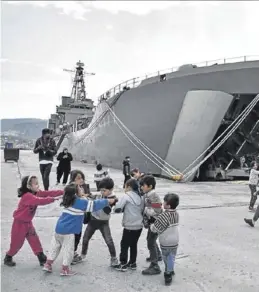  ?? AFP / LOUISA GOULIAMAKI ?? Unos niños juegan en el puerto de Mitilini, junto al buque.