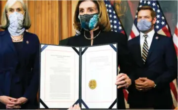  ??  ?? House Speaker Nancy Pelosi of California displays the signed article of impeachmen­t against President T rump in an engrossmen­t ceremony before transmissi­on to the Senate for trial on Capitol Hill.