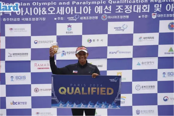  ?? Filipina rower Joanie Delgaco holds a sign indicating her qualificat­ion in the 2024 Paris Olympics. ??