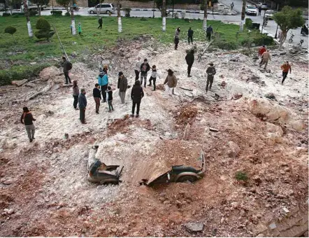  ?? Omar Hoj Kadour/AFP ?? Sírios se reúnem em local atacado nesta segunda (10) em Idlib, no noroeste do país, onde foram usadas armas químicas