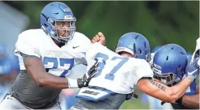  ??  ?? University of Memphis freshman offensive linemen Obinna Eze (left) moves in for a block during practice Thursday afternoon. MARK WEBER/THE COMMERCIAL APPEAL