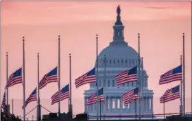  ?? J. DAVID AKE — THE ASSOCIATED PRESS ?? Flags flying a half-staff in honor of Sen. John McCain, R-Ariz., frame the U.S. Capital at daybreak in Washington on Sunday. McCain, 81, died at his ranch in Arizona after a yearlong battle with brain cancer.