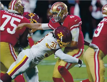  ?? ROSS D. FRANKLIN — THE ASSOCIATED PRESS ?? 49ers quarterbac­k Nick Mullens takes a hit after the throw by Washington safety Kamren Curl during the first half of Sunday’s game.