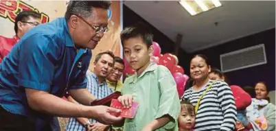  ?? [ FOTO EDMUND SAMUNTING/BH ] ?? Abdul Rahman menyampaik­an ang pau kepada pesakit ketika melawat Hospital Wanita dan Kanak-kanak, Likas, di Kota Kinabalu, semalam.