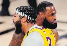  ??  ?? Lakers forward Anthony Davis, left, celebrates with teammate LeBron James after a dunk against the Heat during Game 1 on Wednesday in Lake Buena Vista, Florida.
