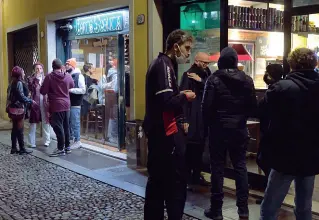  ??  ?? Piccoli capannelli Clienti davanti a uno dei bar, ieri sera, in zona Ghetto Da oggi (in teoria) tutto questo sarà proibito