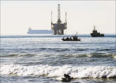  ?? Irfan Khan Los Angeles Times ?? BOATS SURVEY the water after an oil sheen was spotted off the coast of Bolsa Chica State Beach in Orange County this month.