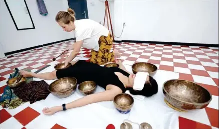  ?? HONG MENEA ?? Dufrenne conducts a therapy session by placing singing bowls around her client to immerse them in healing vibrations.