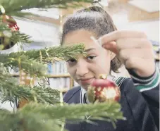  ??  ?? Hannah Clark (13) decorates the Fulwell Library Christmas Tree.