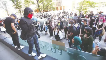  ?? PHOTOS: JIM WELLS ?? Speakers gather on the front of the downtown CBE building on Friday in support of the Black Lives Matter movement. About 200 marchers were escorted by police from Kensington to the Calgary Board of Education Building, then to city hall.