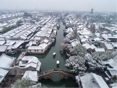  ??  ?? 2018 年 12 月 9日，空中俯瞰被白雪覆盖的­乌镇景区(徐昱/摄)