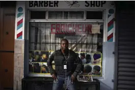 ?? RAMON ESPINOSA — THE ASSOCIATED PRESS ?? Philocles Julda, 44, stands in front of a Haitian barbershop in Tijuana, Mexico, on Thursday. Julda is part of a group of Haitian immigrants in the city.