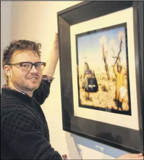  ?? LYNN CURWIN/TRURO NEWS ?? Brandt Eisner hangs Weather Cancellati­on, a work of art he and Susan Malmstrom created, on a wall of the gallery at the Marigold Cultural Centre. The piece is one of those included in the Odd Jobs exhibit, which opens Saturday.