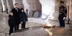  ??  ?? Emmanuel Macron se recueillan­t devant la flamme à l’ossuaire de Douaumont entouré de deux jeunes enfants. (Photo EPA)