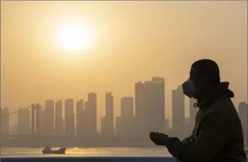  ?? Ng Han Guan/Associated Press ?? A man wearing a mask is silhouette­d as the sun sets along the riverbank on Jan. 15 in Wuhan, China, where a little more than a year ago, the novel coronaviru­s was first identified.