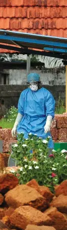  ??  ?? Doctors and relatives wearing protective gear carry the body of a Nipah virus victim, who died on May 24, at a burial ground in Kozhikode, Kerala