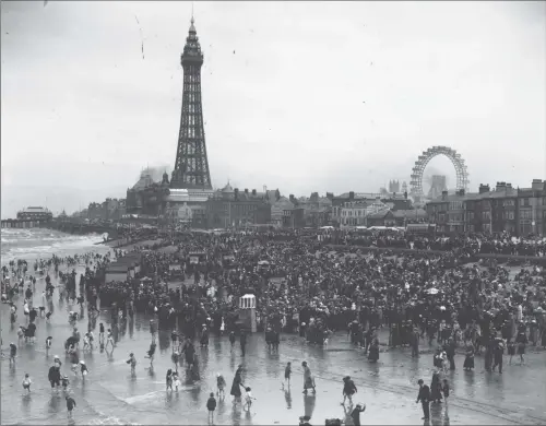  ?? PICTURE: CENTRAL PRESS/GETTY IMAGES. ?? BESIDE THE SEASIDE: A huge crowd on the beach at Blackpool, with the famous Tower and Big Wheel behind them.