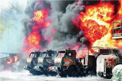  ?? AP ?? Vehículos de un depósito petróleo arden tras el impacto de un misil en la zona de Donetsk por los prorrusos