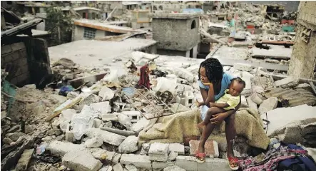  ?? CHIP SOMODEVILL­A / GETTY IMAGES ?? Homes collapsed after a Port-Au-Prince earthquake, vs. rustic boats on an idyllic Haiti beach.