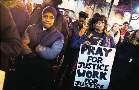  ?? AFP ?? Tension in the air People gather outside Chicago police headquarte­rs for a prayer vigil and demonstrat­ion to protest the alleged cover-up of Laquan McDonald’s killing. The University of Chicago was closed after an online threat against whites on campus...