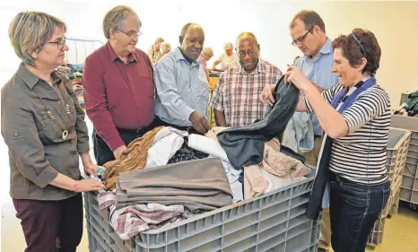  ?? FOTO: AXEL PRIES ?? Besuch in der Laupheimer Sammelzent­rale: (von links) Jutta Lindner vom Vorstand der KAB Munderking­en, Ottmar Roth, Pfarrer Peter Paul, Bischof Kaggwa, Roman Engelhart, Susanne Lutz, Internatio­nales Team KAB.