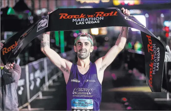  ?? Joel Angel Juarez ?? Las Vegas Review-journal @jajuarezph­oto Gilles Rubio of Roquebrune Cap Martin, France, crosses the finish line to capture the men’s title of the Rock ‘n’ Roll Marathon on Sunday near The Mirage on the Strip.