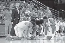  ?? THE ASSOCIATED PRESS ?? Members of Tennessee’s men’s basketball team pause to pray as Mississipp­i State’s Nick Weatherspo­on is examined by medical personnel during Friday night’s SEC tournament quarterfin­als in St. Louis.