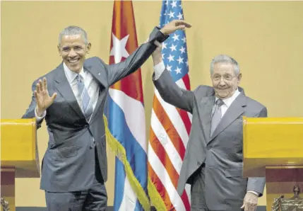  ?? (Photos: AP) ?? In this March 21, 2016 file photo, Cuban President Raul Castro (right) lifts up the arm of US President Barack Obama at the conclusion of their joint news conference at the Palace of the Revolution, in Havana, Cuba. Obama was joined by wife Michelle Obama and daughters Malia and Sasha in the first visit by a sitting US president to the island nation in 88 years.