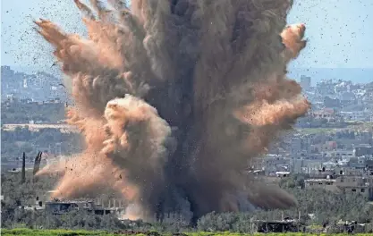  ?? OHAD ZWIGENBERG/AP ?? An explosion rocks the Gaza Strip on Wednesday, as seen from southern Israel. Warfare and the breakdown of public order have nearly halted aid deliveries.