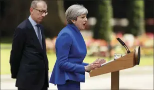  ??  ?? British Prime Minister Theresa May speaks watched by her husband Philip in 10 Downing street, London, as she addresses the press Friday following an audience with Britain’s Queen Elizabeth II at Buckingham Palace where she asked to form a government....
