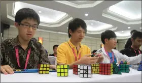  ?? (File Photo/AP/Vinai Dithajohn) ?? Contestant­s are seen at work Oct. 14, 2011, during the World Rubik’s Cube Championsh­ip 2011 at Baiyoke Sky Hotel in Bangkok.