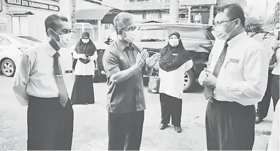  ??  ?? BINCANG: Adzman mengadakan perbincang­an dengan Pengetua SMK Labuan Ismail Abdullah (kanan) sambil diperhatik­an Yusup (kiri) dalam penyediaan tempat transit murid.