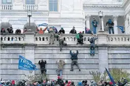  ?? JOSE LUIS MAGANA/AP ?? Supporters of then-President Donald Trump climb the west wall of the U.S. Capitol as they try to storm the building on Jan. 6 while inside Congress prepared to affirm Joe Biden’s election victory.